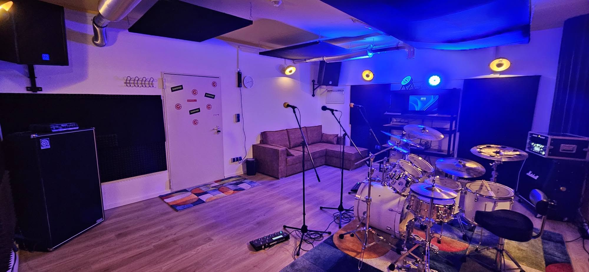 Blick in den Analog-Proberaum mit Schlagzeug, Sofa und Mikrofonen
