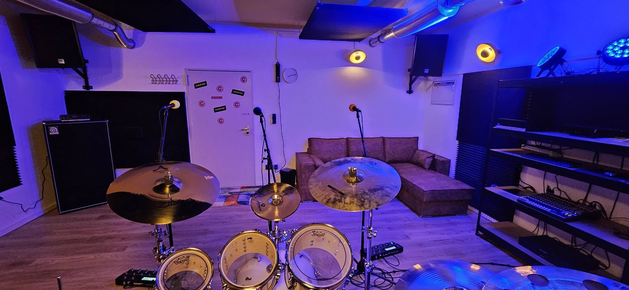 Blick vom Schlagzeug auf Mikrofone, Sofa und analogen Mixer