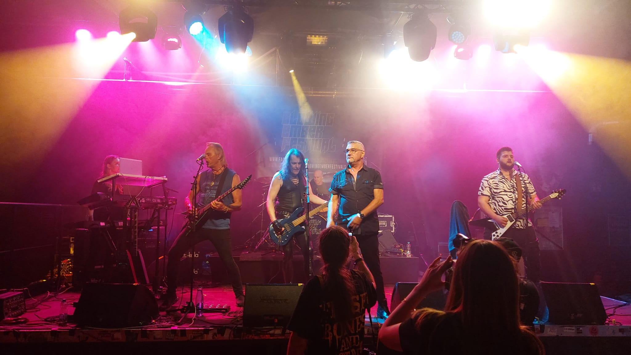 Steel Dawn live mit sechs Musikern auf einer bunt beleuchteten Bühne